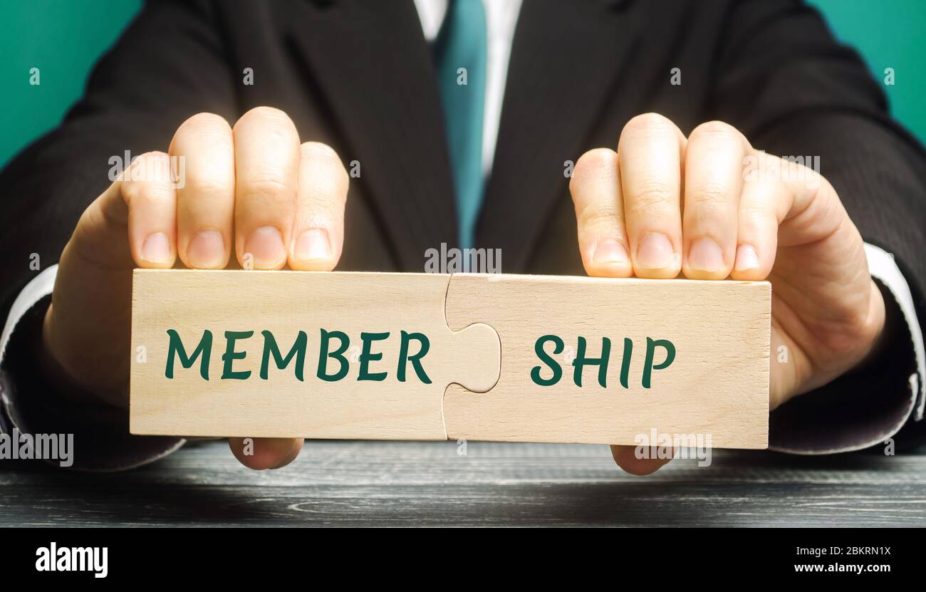Homme d'affaires collecte des puzzles en bois avec les mots adhésion. Appartenance des personnes à l'organisation, à la société, à l'association. Concept d'entreprise Banque D'Images