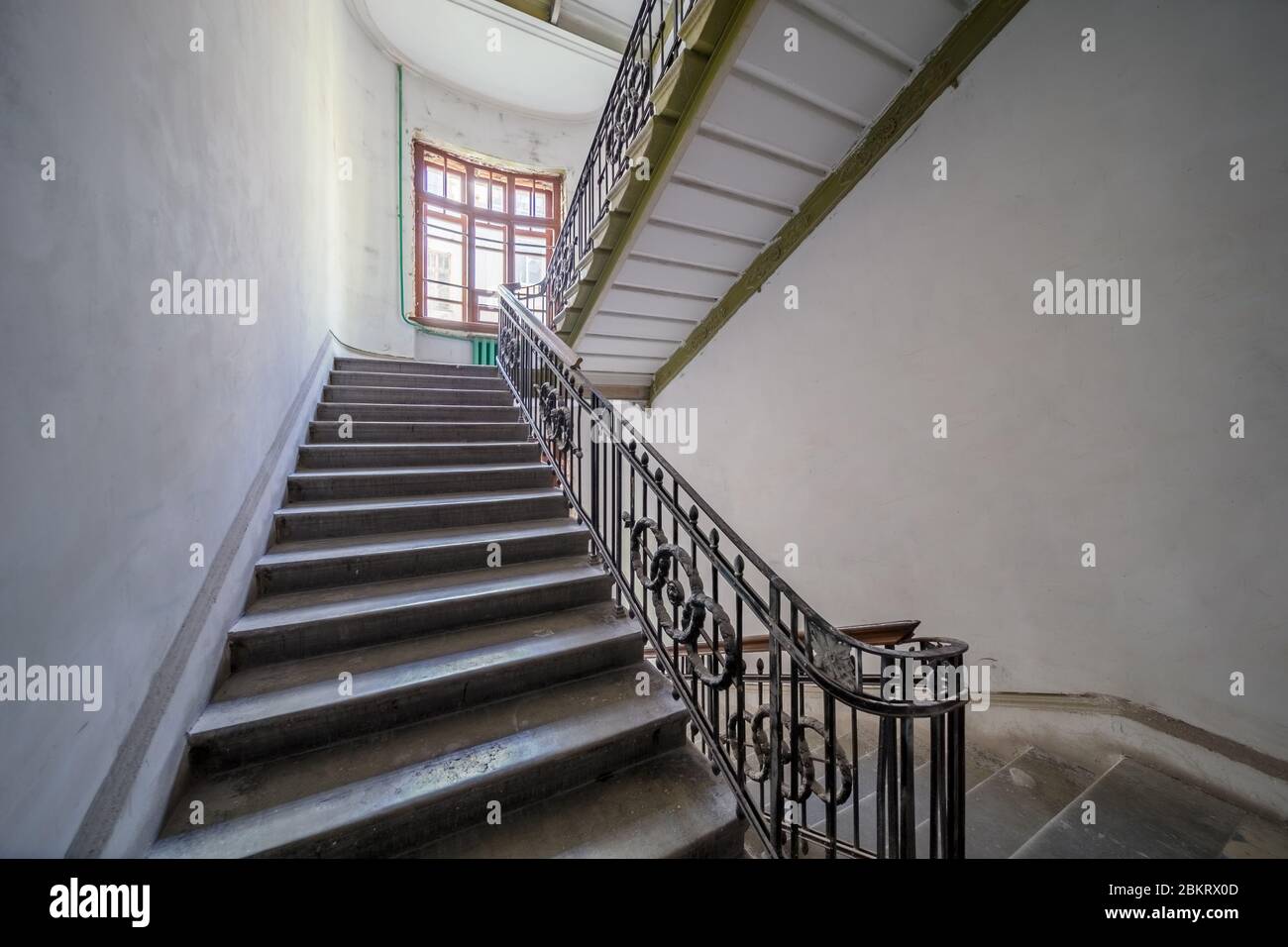 Escaliers dans l'entrée du bâtiment ancien avec escalier symétrique et hauts plafonds Banque D'Images