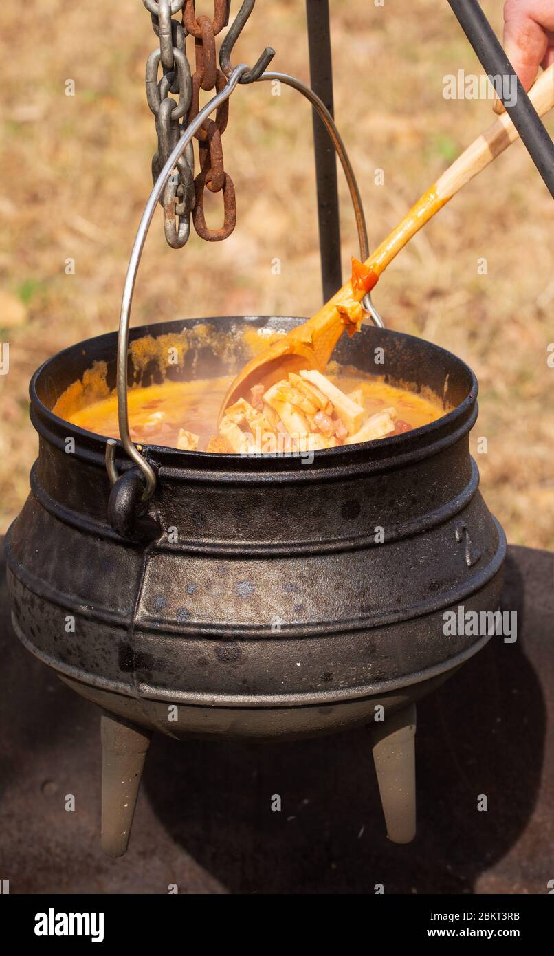 Cuisinez dans une casserole en fonte de pot sur feu ouvert à l'extérieur Banque D'Images