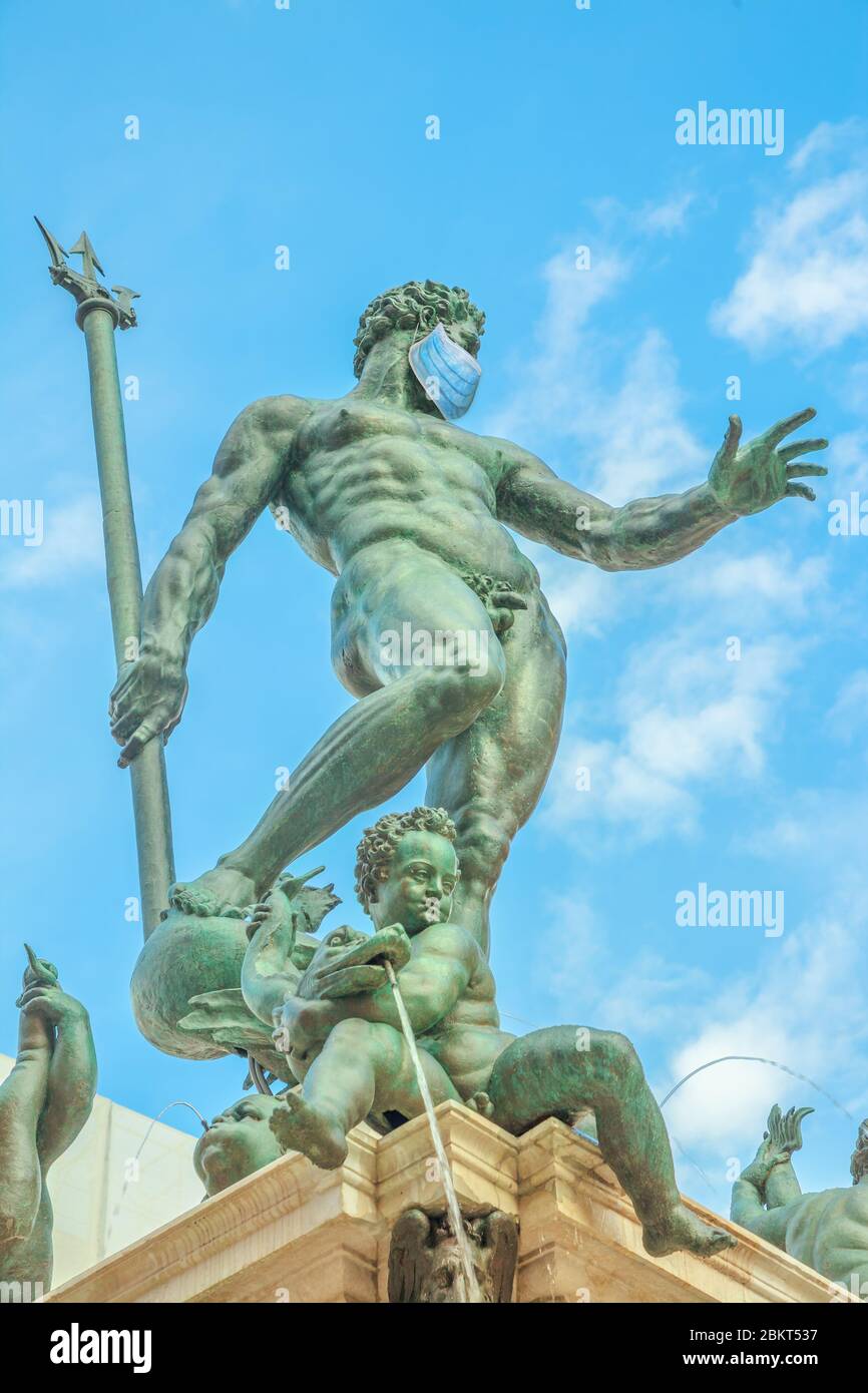 Gros plan de la Statue de Neptune avec masque chirurgical, symbole de la ville de Bologne pendant le temps Covid-19. L'Italie et la pandémie du COV-2 du SRAS. Coronavirus italien Banque D'Images