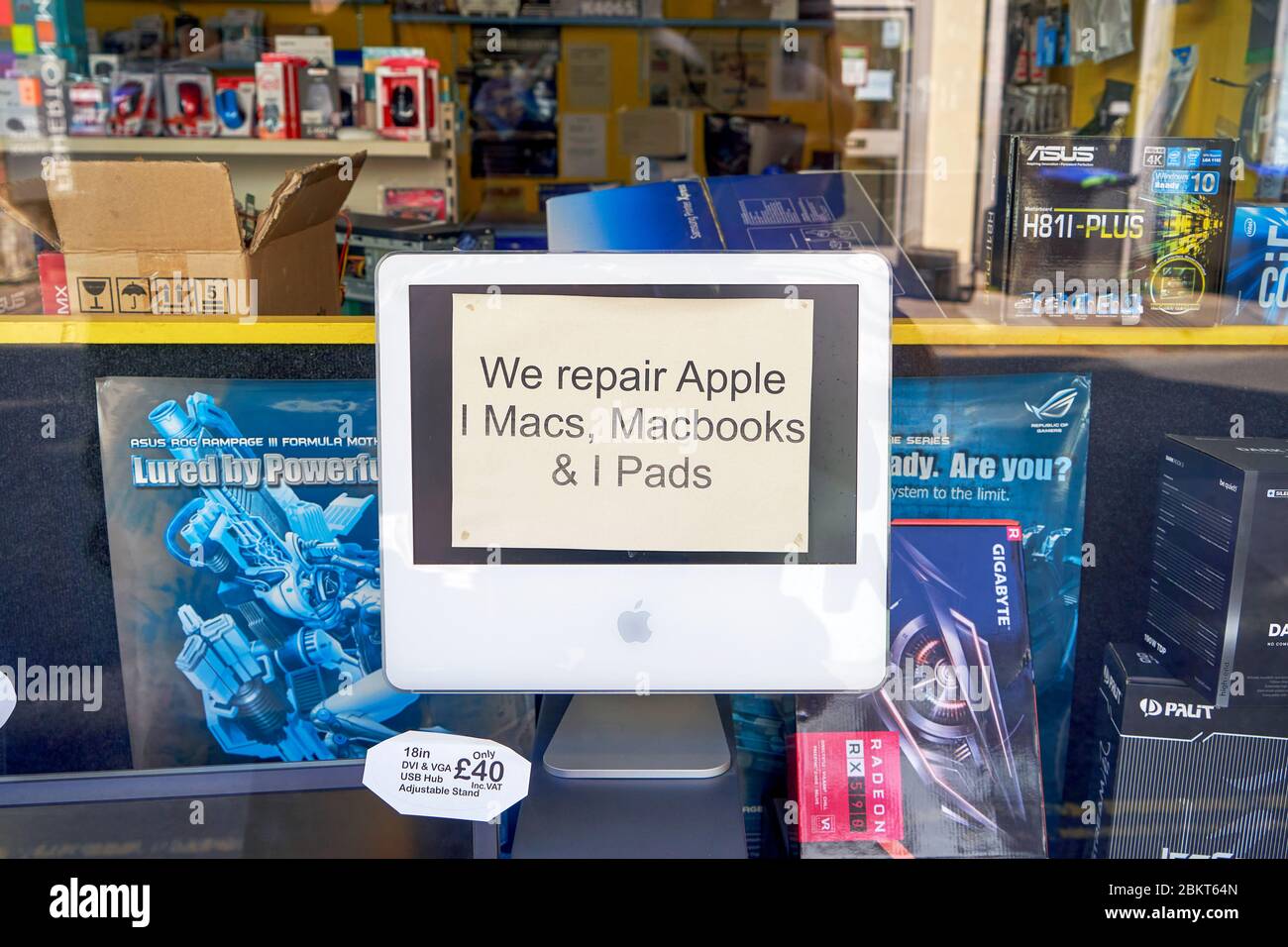 Ancien ordinateur iMac dans la fenêtre de la boutique avec avis annonçant un service de réparation pour les appareils Apple Banque D'Images