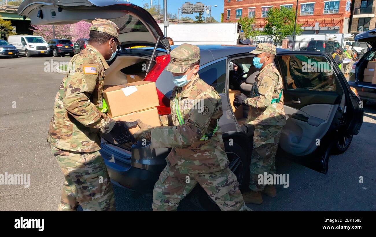 Les soldats de la Garde nationale de New York participent à la distribution de nourriture en réponse à la pandémie de coronavirus COVID-19 au Al Oerter Recreation Centre le 3 mai 2020 à Queens, New York. En moyenne, plus de 100,000 repas par jour sont livrés aux personnes dans le besoin dans les cinq quartiers de New York. Banque D'Images