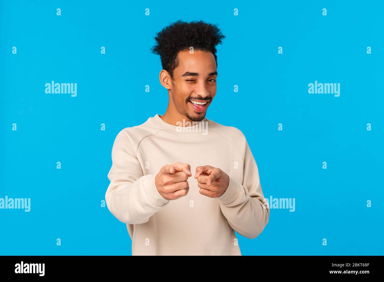 Vous rock, félicitations. Sassy bon-regardant africain american hipster gars pointant les doigts à l'appareil photo et winking comme le choix, indiquant au gagnant ou Banque D'Images