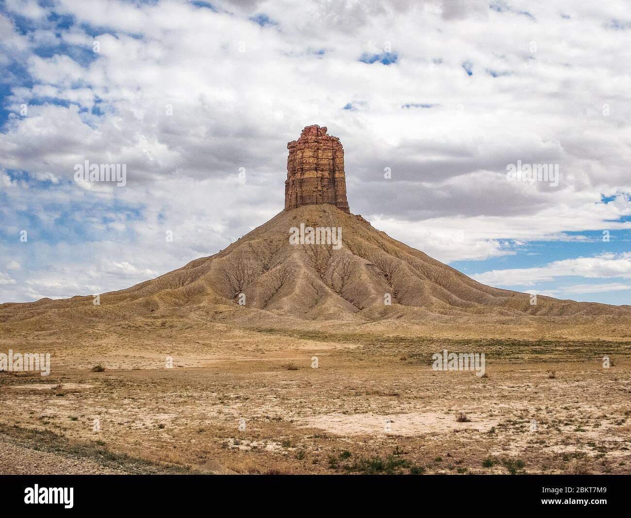 Un seul grand hoodoo ou pilier de roche au milieu du désert du Colorado entouré d'une grande montagne de sable et de roche. Banque D'Images