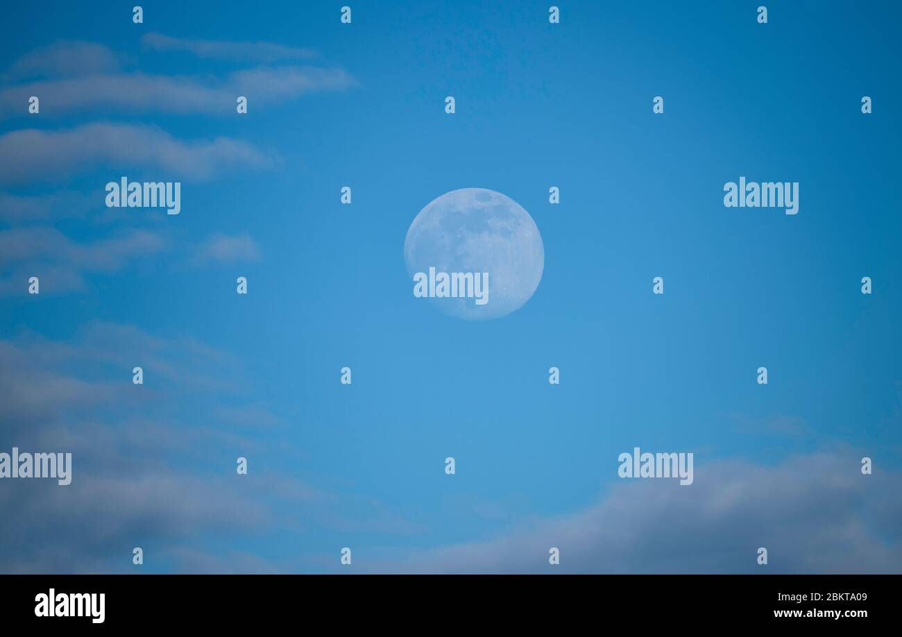 Londres, Royaume-Uni. 5 mai 2020. Phase de lune de gibbous de cire contre le ciel bleu tôt de soirée avec des nuages légers deux jours avant la pleine lune. Crédit: Malcolm Park/Alay Live News. Banque D'Images