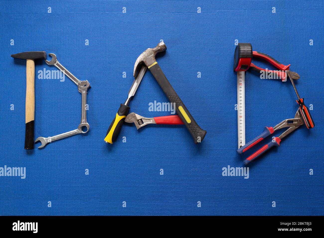 Le mot papa a écrit avec différents outils de main sur fond bleu Banque D'Images Le mot papa a écrit avec différents outils de main sur fond bleu Banque D'Images