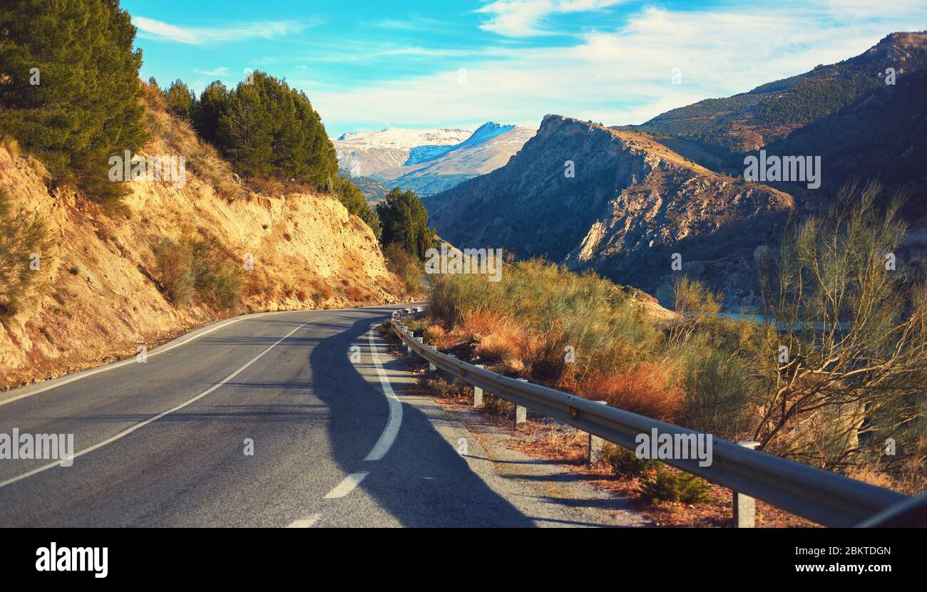 Route pittoresque de montagne sinueuse de campagne menant à la Sierra Nevada, crête enneigée