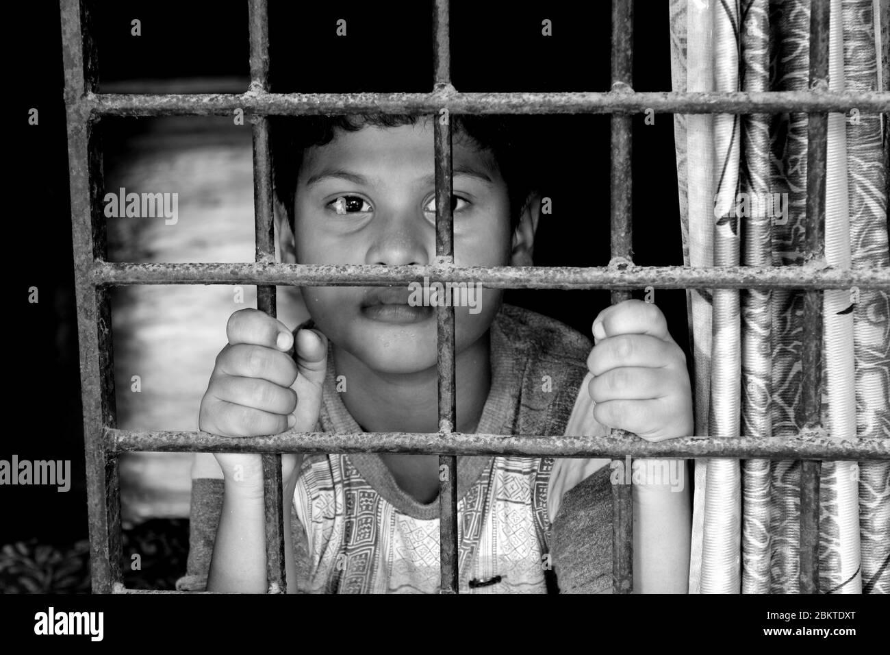 Portrait d'enfant devant la fenêtre. Regard d'enfant curieusement dans le monde. Triste petit garçon forcé de rester à la maison comme coronavirus pandémique Banque D'Images