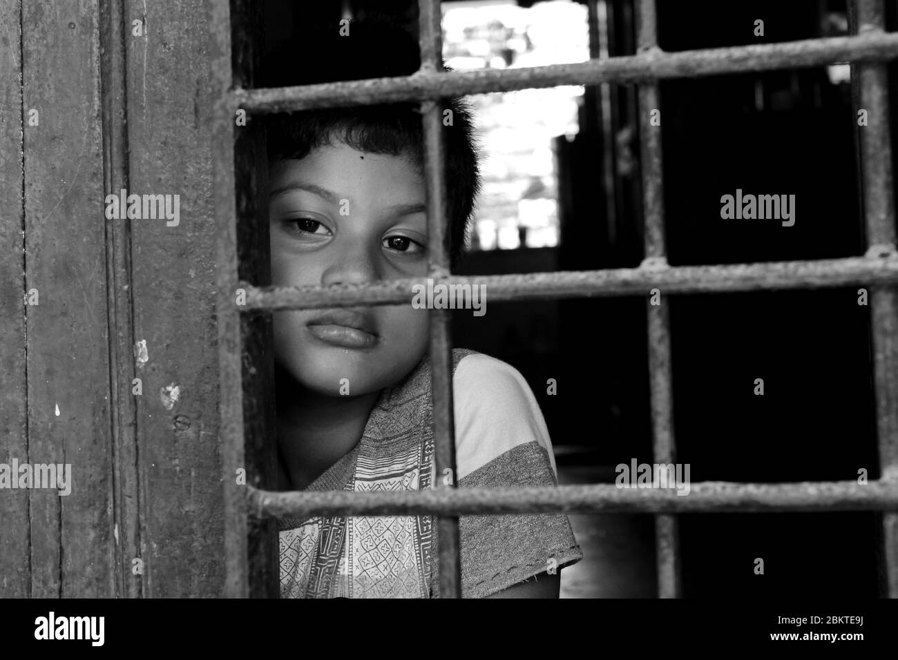 Portrait d'enfant devant la fenêtre. Regard d'enfant curieusement dans le monde. Triste petit garçon forcé de rester à la maison comme coronavirus pandémique Banque D'Images