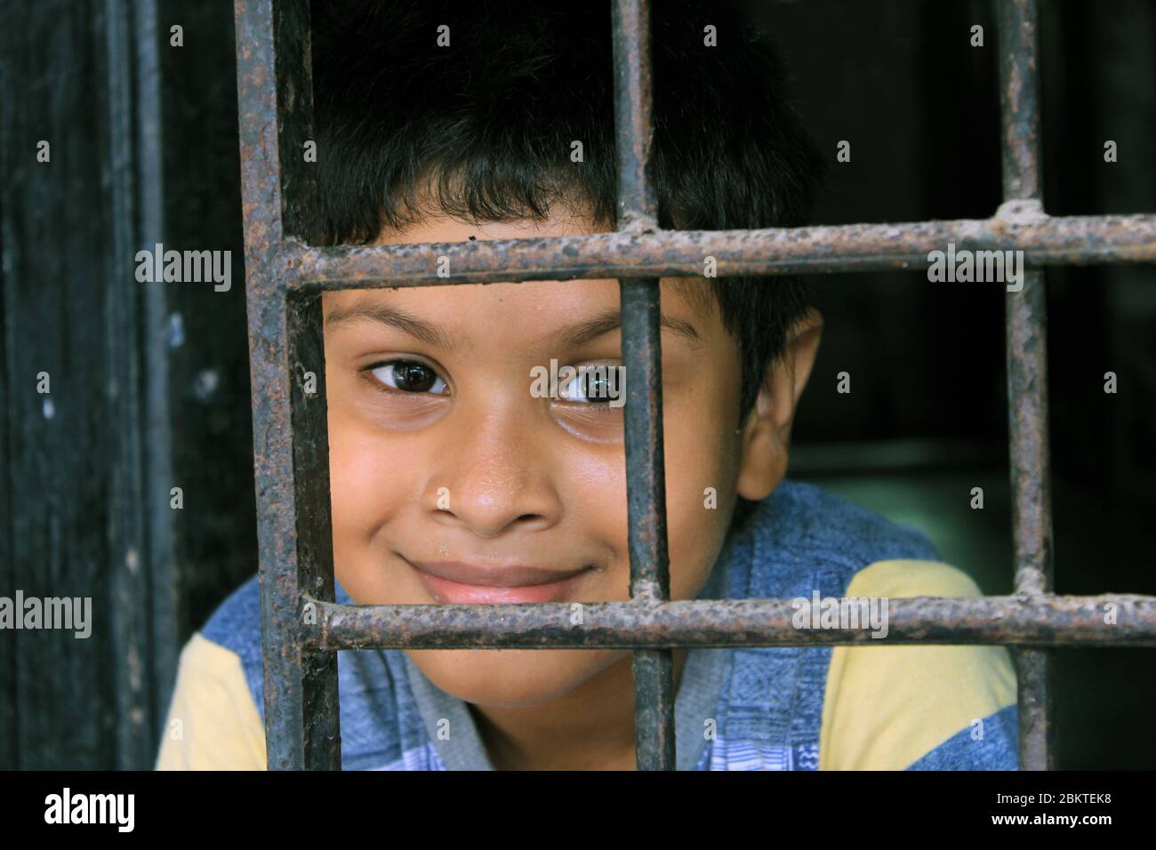 Portrait d'enfant devant la fenêtre. Regard d'enfant curieusement dans le monde. Triste petit garçon forcé de rester à la maison comme coronavirus pandémique Banque D'Images