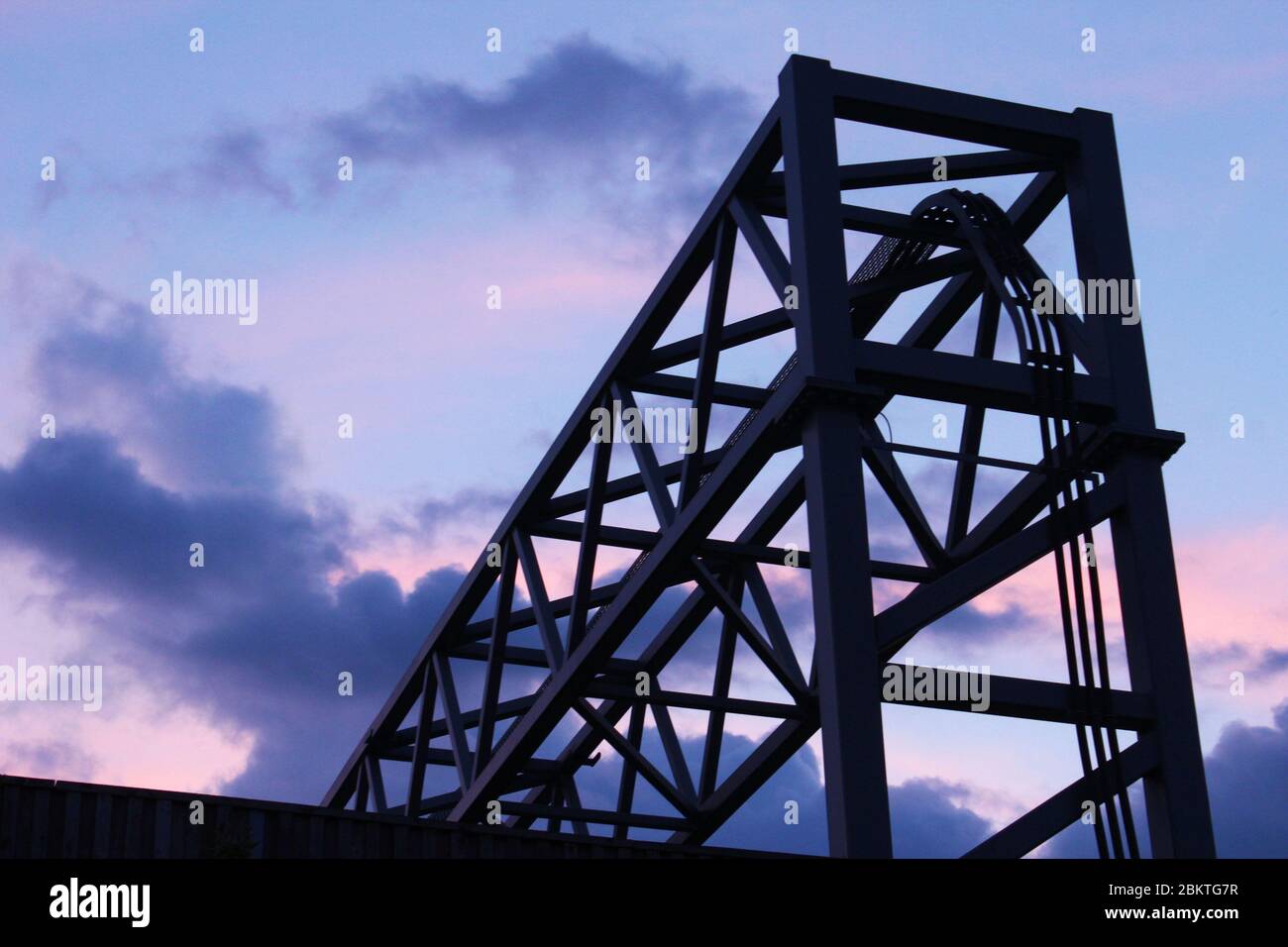 Coucher de soleil violet derrière un portique de cage d'autoroute à Manchester, Angleterre Banque D'Images