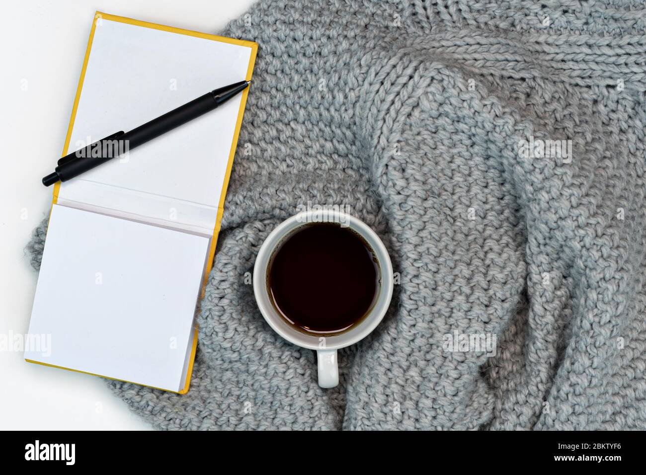 Plat de travail confortable espace de travail avec café chaud, ordinateur portable et accessoires d'écriture. Travail à la maison. Écriture. Concept chaud par temps froid. Banque D'Images