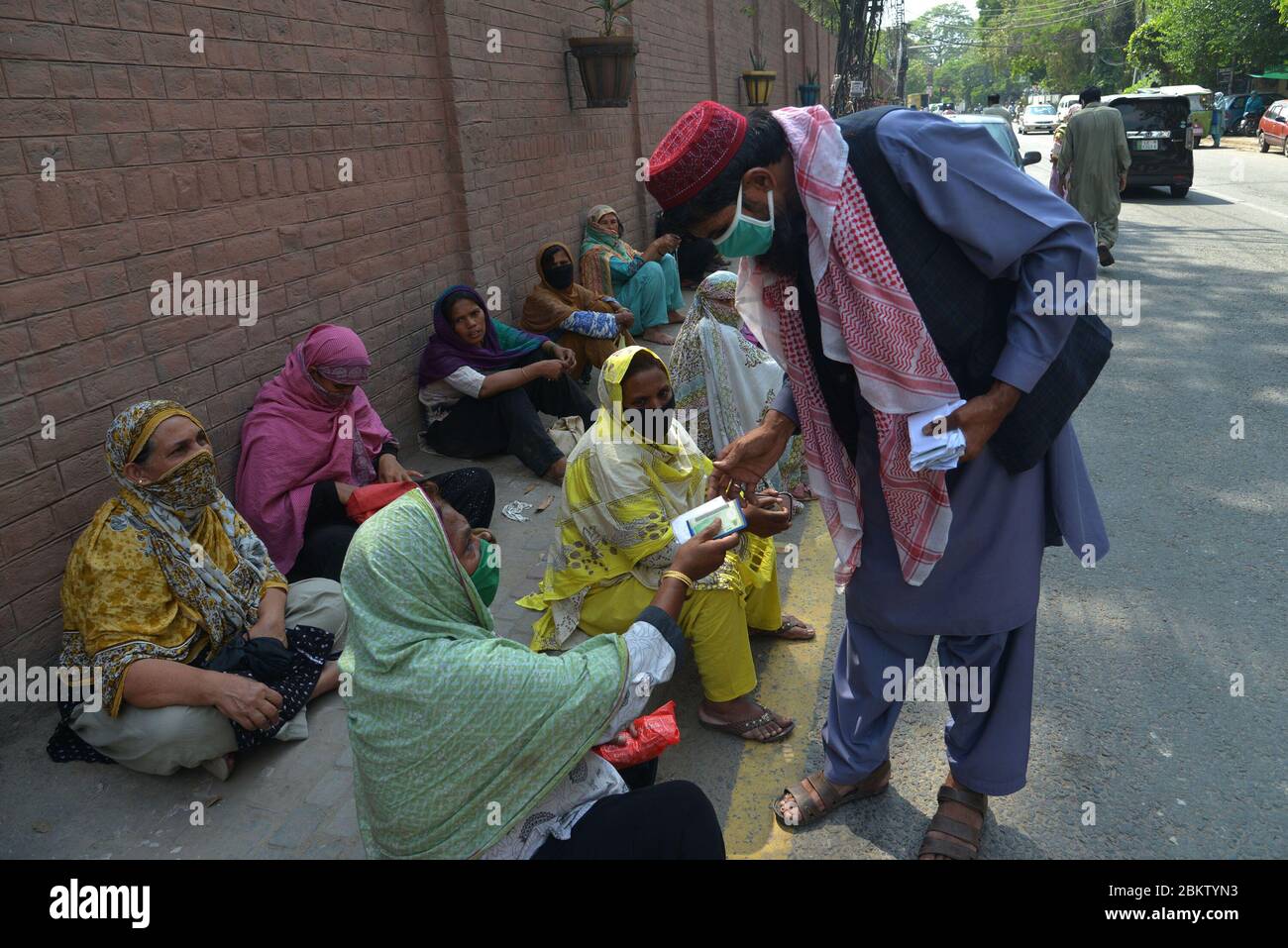 Un grand nombre de personnes se tiennent en file d'attente sans avoir à se distancer au bureau NADRA dans la région de Shimla Hill pour obtenir leurs cartes d'identité nationales. NADRA a rouvert ses bureaux dans tout le pays pour faciliter le grand public à Lahore. Les résidents portant des masques de surveillance se trouvent dans une file d'attente en dehors du bureau de l'autorité nationale de base de données et d'enregistrement (NADRA) pour les nouveaux enregistrements et la vérification biométrique dans le cadre du Programme gouvernemental de trésorerie d'urgence Ehsaas pour les familles dans le besoin, dans le cadre d'un verrouillage national imposé par le gouvernement, comme mesure préventive contre la COVID-19. (Photo de Rana S Banque D'Images