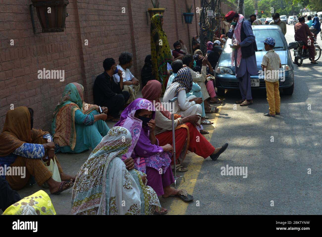 Un grand nombre de personnes se tiennent en file d'attente sans avoir à se distancer au bureau NADRA dans la région de Shimla Hill pour obtenir leurs cartes d'identité nationales. NADRA a rouvert ses bureaux dans tout le pays pour faciliter le grand public à Lahore. Les résidents portant des masques de surveillance se trouvent dans une file d'attente en dehors du bureau de l'autorité nationale de base de données et d'enregistrement (NADRA) pour les nouveaux enregistrements et la vérification biométrique dans le cadre du Programme gouvernemental de trésorerie d'urgence Ehsaas pour les familles dans le besoin, dans le cadre d'un verrouillage national imposé par le gouvernement, comme mesure préventive contre la COVID-19. (Photo de Rana S Banque D'Images