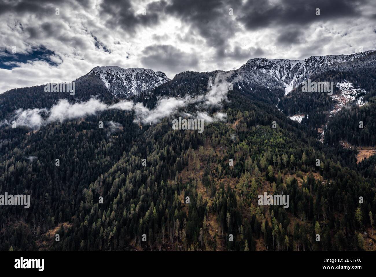 Vue aérienne de la vallée avec des pentes vertes des montagnes de l'Italie temps nuageux, Trentin, les arbres dégringolés par un vent, d'énormes nuages sur un Banque D'Images