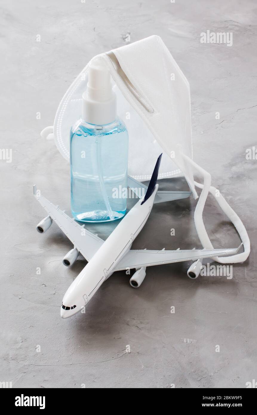 Coronavirus et concept de voyage. Restrictions ou autorisation de voyager pendant la quarantaine. Vacances annulées. Modèle d'avion avec masque facial et main sa Banque D'Images
