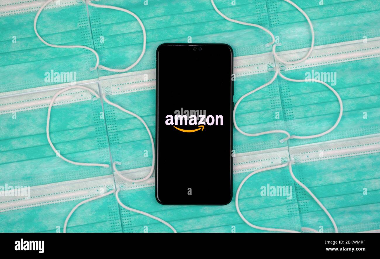 Logo Amazon sur l'écran noir du smartphone, placé sur le dessus des masques antiviraux. Pose à plat. Concept pour le shopping Amazon pendant la pandémie de COVID-19 Banque D'Images