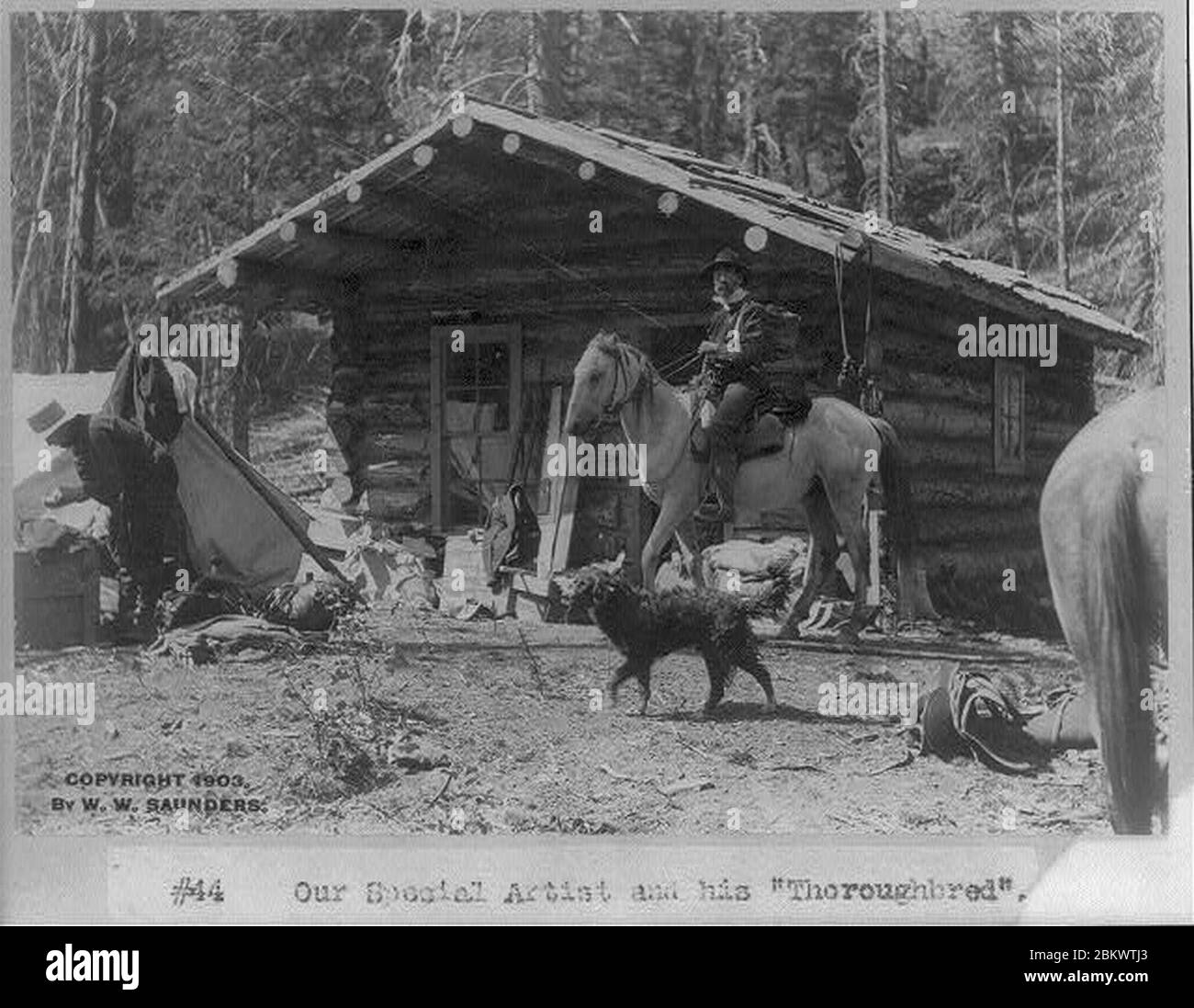 Idaho - Roosevelt- «notre artiste spécial et son 'pur-sang'» (homme à cheval devant la cabane en rondins) Banque D'Images