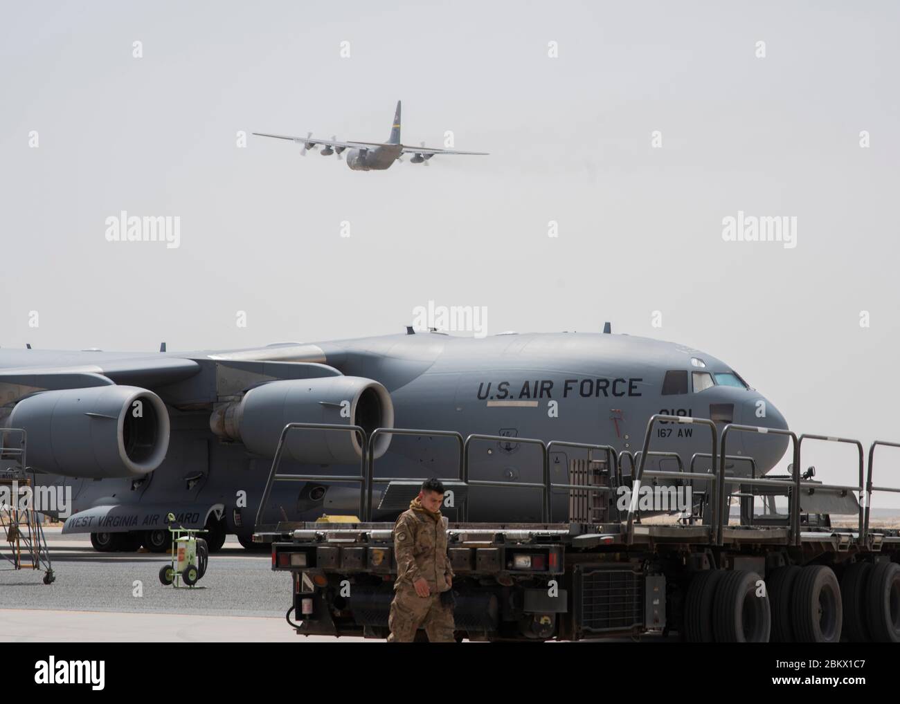 Un C-17 Globemaster III, déployé à partir de la 167e Escadre de transport aérien, Garde nationale aérienne de Virginie-Occidentale, est situé sur la ligne aérienne comme un C-130 au-dessus de la base aérienne Ali Al Salem, au Koweït, le 2 mai 2020. La 386e Escadre expéditionnaire aérienne est la porte d’entrée du Commandement Central des États-Unis et est responsable de fournir une puissance de combat décisive et un soutien théâtral inégalé. (ÉTATS-UNIS Photo de la Force aérienne par le premier Airman Isaiah J. Soliz) Banque D'Images