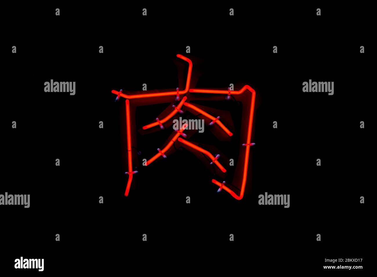 Scène dans laquelle le néon rouge du caractère « meat » écrit en caractères chinois brille dans le noir Banque D'Images