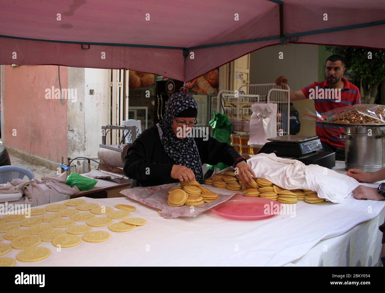 Gaza. 4 mai 2020. Nahida al-Nimr fabrique des bonbons traditionnels appelés « Qatayef », un dessert typique du mois Saint du Ramadan, dans une petite tente dans le quartier de Tal al al-Hawa à Gaza, le 4 mai 2020. Nahida al-Nimr, dans ses années 60, était occupée à vendre son Qatayef spécial à des clients. POUR ALLER AVEC: 'Feature: Les femmes palestiniennes cuisent pour gagner de l'argent pour la vie pendant le Ramadan' crédit: Rizek Abdeljawad/Xinhua/Alamy Live News Banque D'Images