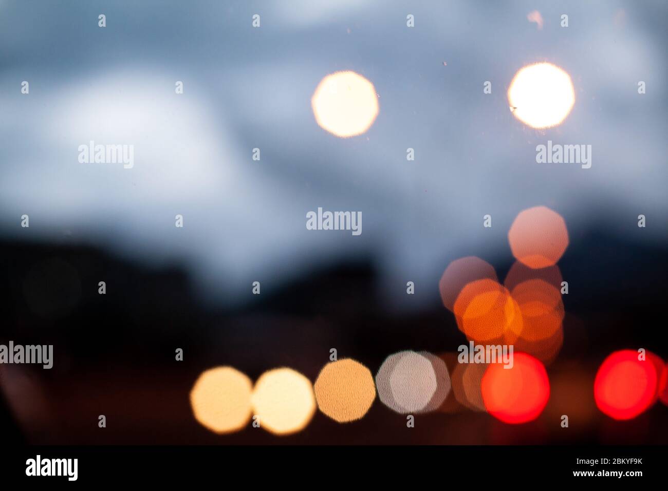 Flou urbain texture abstraite bokeh lumières de ville et bouchons de circulation. Vue depuis le pare-brise de la cabine. Mise au point douce. Banque D'Images