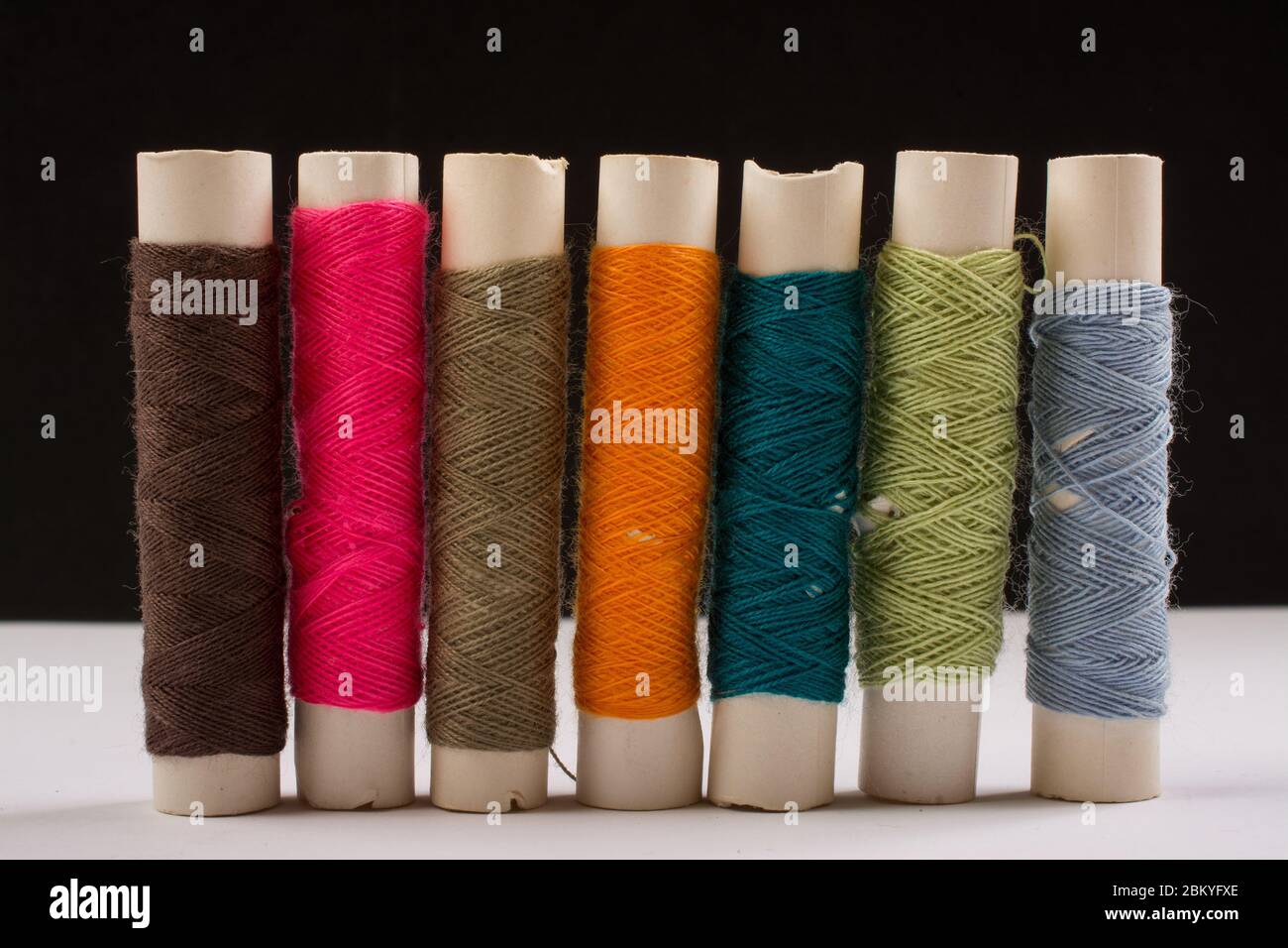 Fils de coton colorés sur rouleaux pour la couture. Bobines de filetage utilisées dans l'industrie textile et textile Banque D'Images