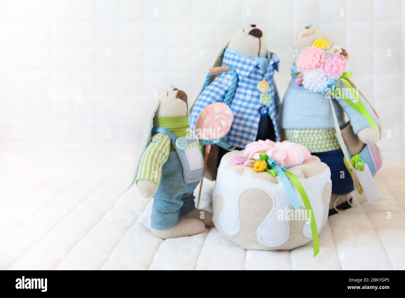 Jouet fait main. Poupée de textiles. Lapins familiaux avec gâteau cousu à la main. Banque D'Images