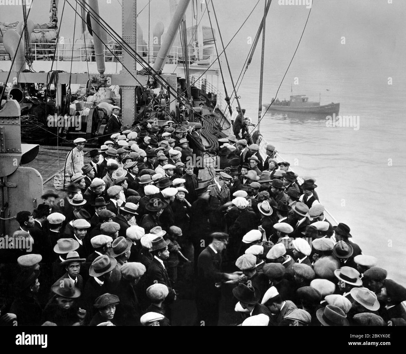 Immigrants arrivant par bateau à Ellis Island à New York. Banque D'Images