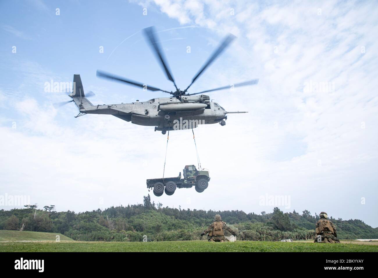 Les Marines des États-Unis avec combat Logistics Battalion 4, 3e Marine Logistics Group, regardez comme un CH-53E Super Stallion lève la cargaison simulée à la zone d'atterrissage Swan, Okinawa, Japon, le 1er mai 2020. La CLB-4 a mené des opérations de l'équipe de soutien aux hélicoptères pour former des spécialistes et des pilotes de soutien à l'atterrissage afin de transférer de l'équipement lourd et des fournitures avec un hélicoptère CH-53E Super Stallion. (ÉTATS-UNIS Photo du corps marin par PFC. Courtney A. Robertson) Banque D'Images