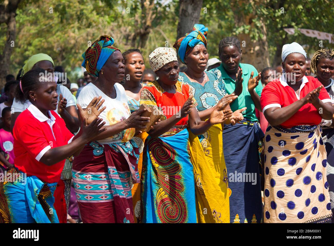 Femmes dansant et chantant vêtues de tissus africains traditionnels colorés connus sous le nom de capulana au Mozambique Banque D'Images