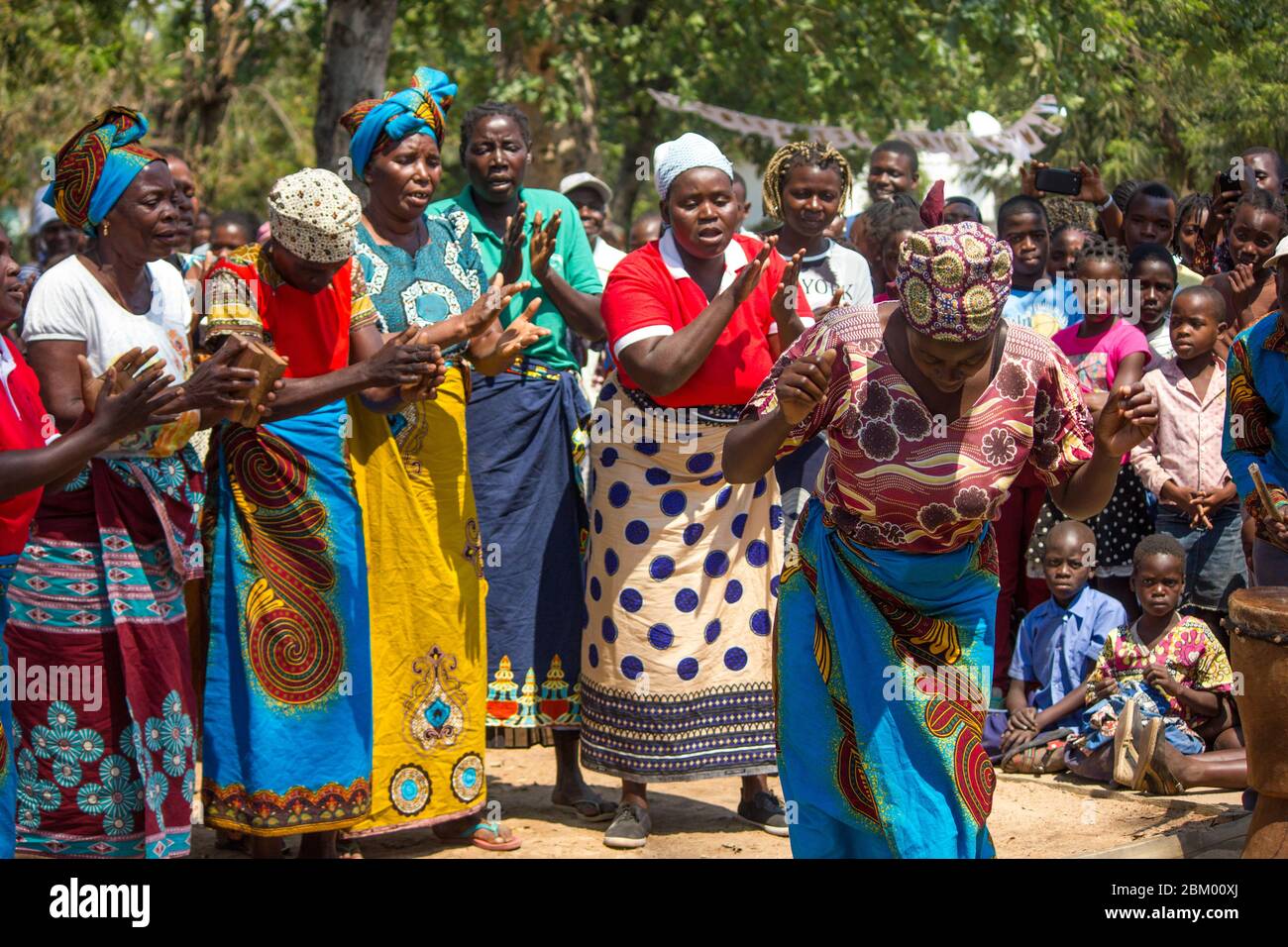 Femmes dansant et chantant vêtues de tissus africains traditionnels colorés connus sous le nom de capulana au Mozambique Banque D'Images