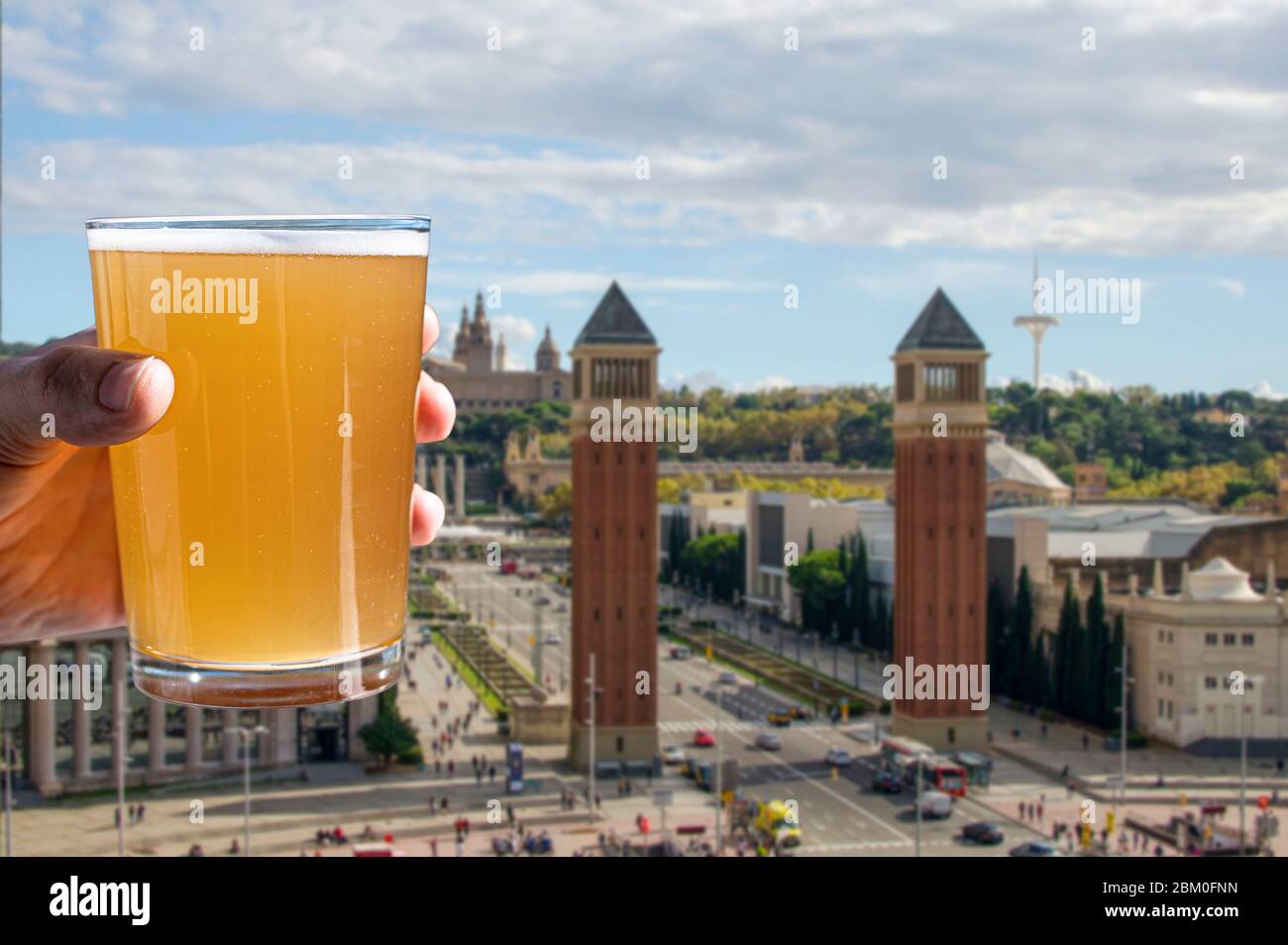 Verre de bière avec vue sur la place de l'Espagne à Barcelone, Espagne. Homme tenant un verre de bière froide de blé léger. Banque D'Images