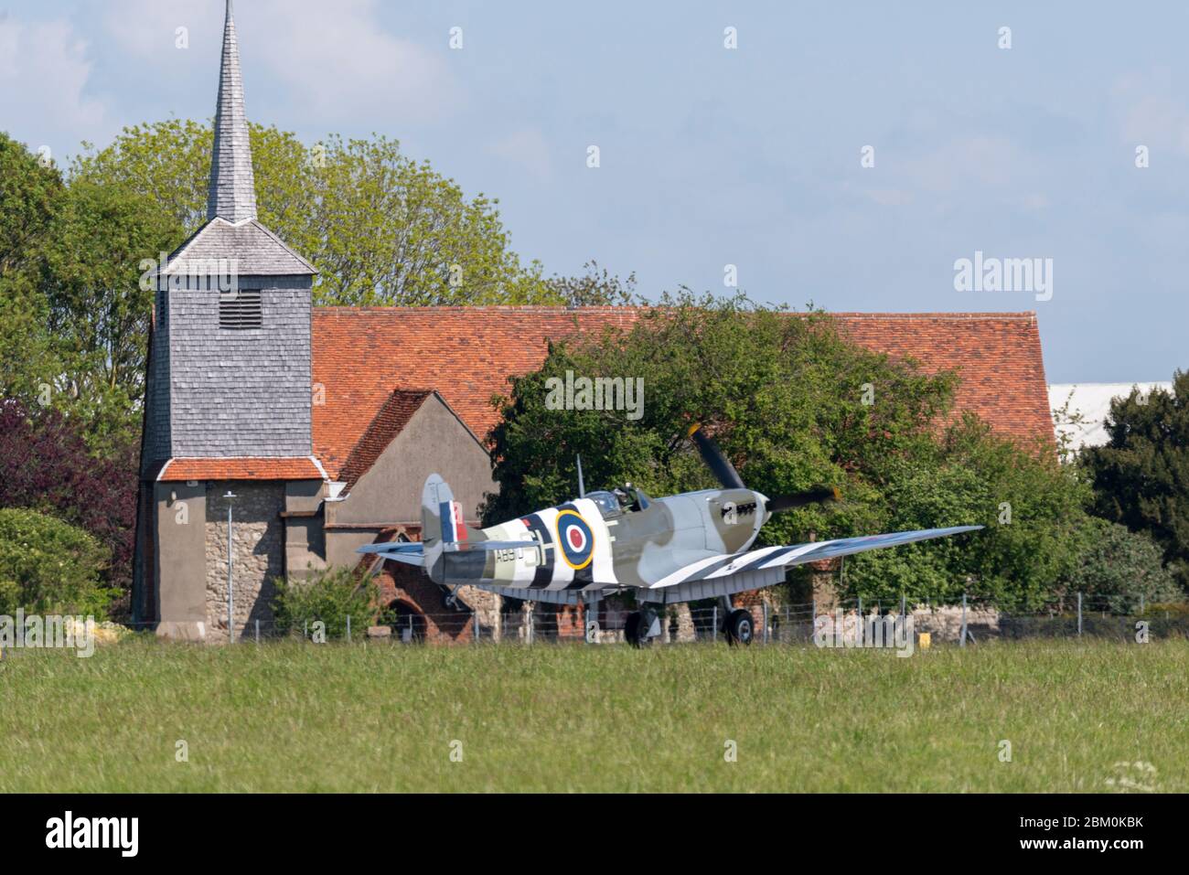 Aéroport de Londres Southend, Essex, Royaume-Uni. 6 mai 2020. Deux Spitfires, vol commémoratif de la Royal Air Force Battle of Britain, ont atterri à l'aéroport de Southend pour faire le plein de carburant et être prêts à filmer des falaises blanches de Douvres pour une diffusion télévisée du 75e anniversaire du Ve jour. Spitfires a servi la RAF pendant la guerre à la RAF Rochford, qui a maintenant été développée dans l'aéroport Southend de Londres. Spitfire AB910 est un Mark Vb avec des bandes d'invasion du jour J, atterrissant par l'église Saint-Laurence et All Saints Banque D'Images