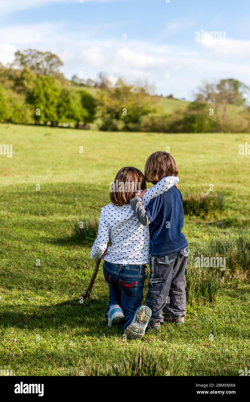 Sœur aînée et frère cadet embrassant dans un paysage de printemps pittoresque, en Angleterre Banque D'Images