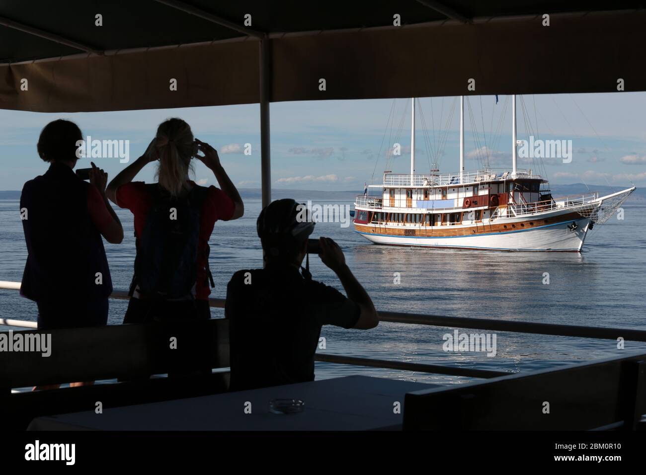Silhouettes de touristes photographiant un navire de tourisme Banque D'Images