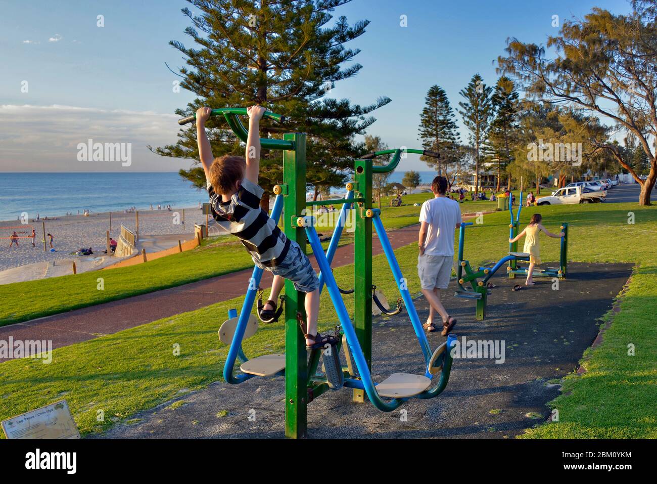 Enfants avec leurs parents dans un terrain de jeu australien situé sur la plage. Banque D'Images
