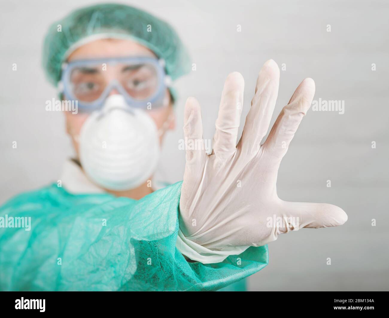 Arrêter coronavirus.médecin travailleur médical montrant un signe d'arrêt sur fond gris, flou d'arrière-plan Banque D'Images