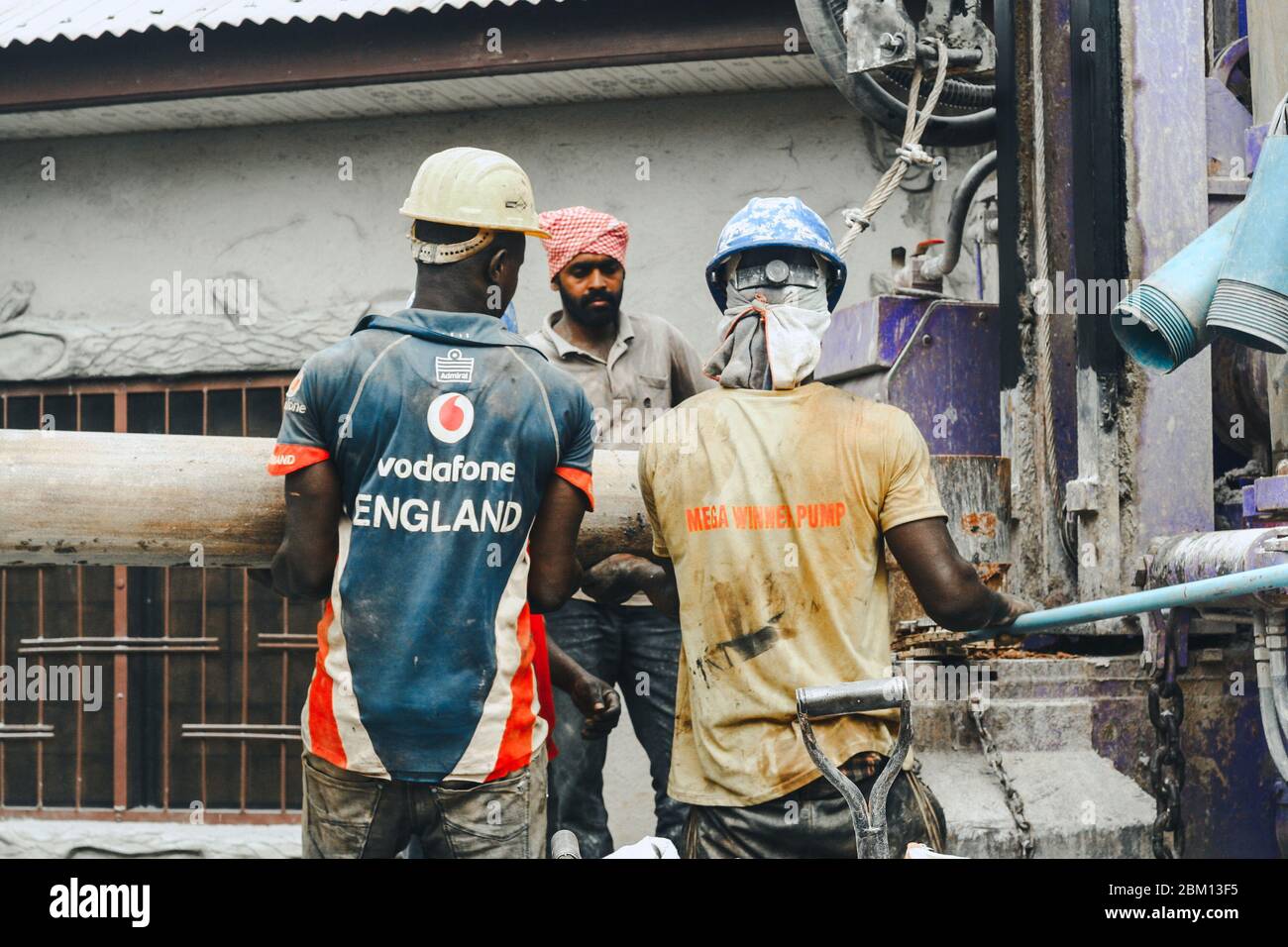 Kumasi,Ghana - 20 avril 2020 : personnes qui font un forage avec une machine de forage et se sentent fatiguées Banque D'Images