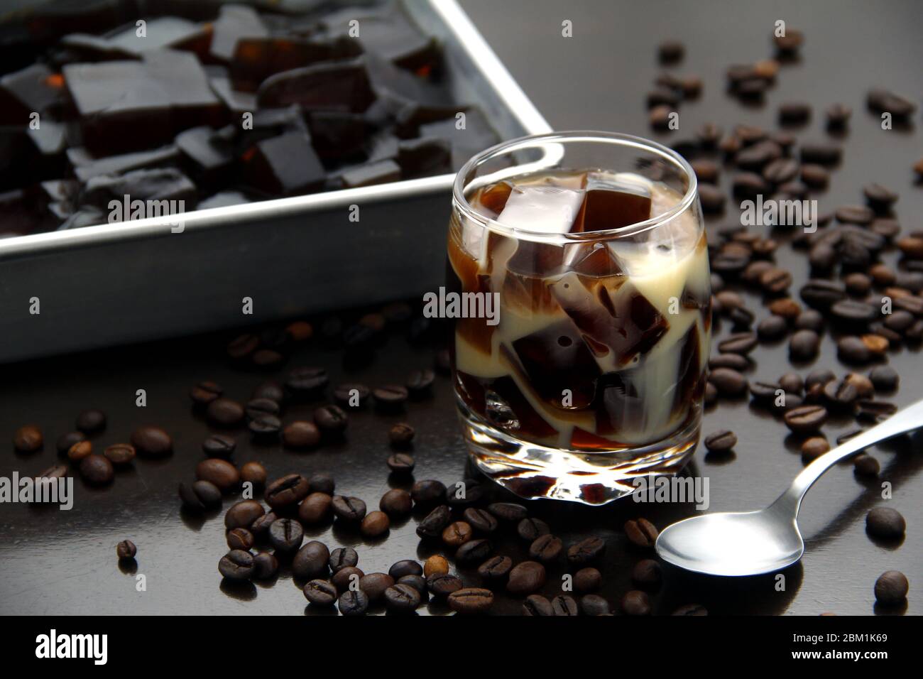Photo de gelée aromatisée au café avec du lait dans un verre transparent sur une table. Banque D'Images