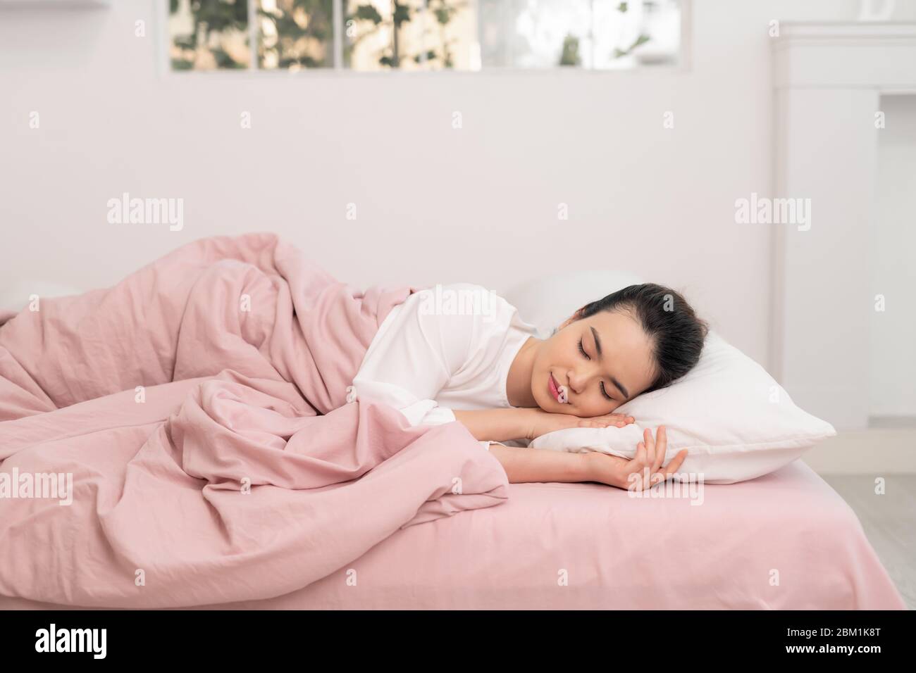 Joyeux Asian jeunes femmes de beauté dormant et sourire sur le lit le matin Banque D'Images