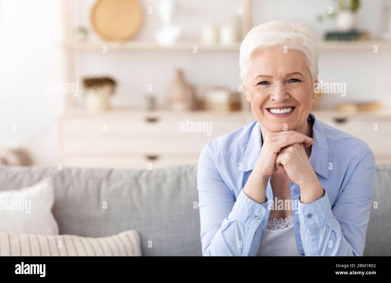 Concept de retraite sécurisée. Portrait d'une femme âgée gaie posant à la maison Banque D'Images