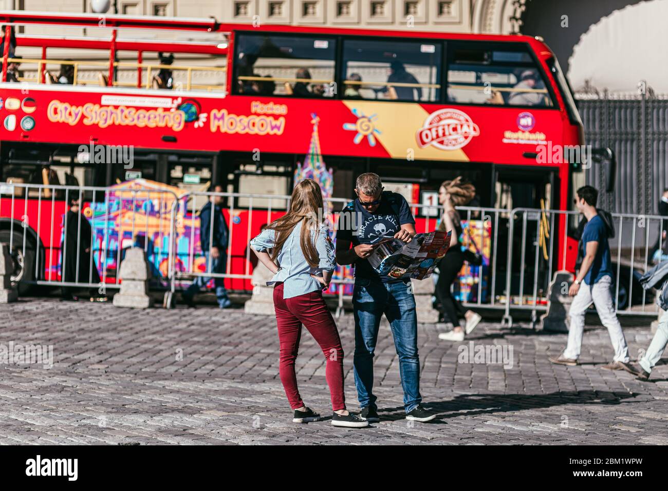 MOSCOU, RUSSIE - 28 MAI 2018 : deux touristes se trouvent sur la place rouge et regardent la carte sur fond de rouge à impériale Banque D'Images