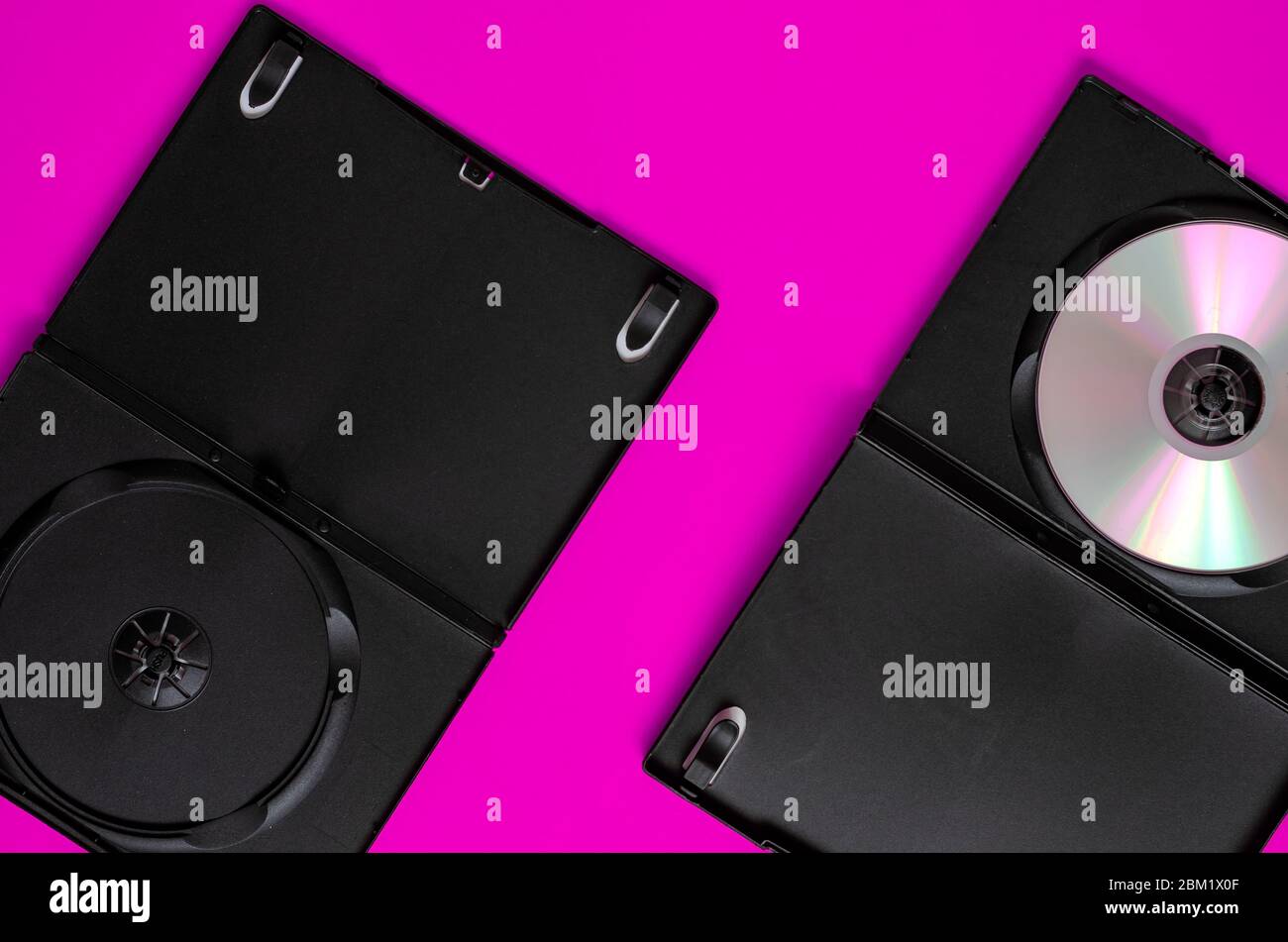 Fond violet avec boîtes ouvertes pour dvd. Boîtes en plastique noir pour disques compacts. Placer pour le texte. Vue de dessus. Banque D'Images