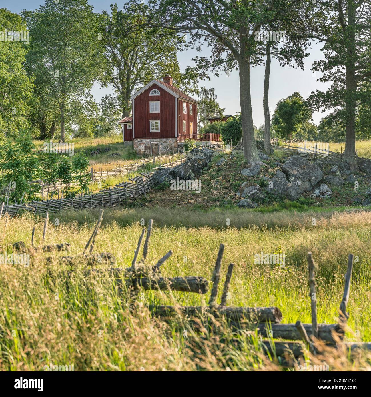 Petite route de campagne et vieux cottages traditionnels rouges dans un paysage rural au village Stensjo by. Oskarshamn, Smaland, Suède, Scandinavie Banque D'Images