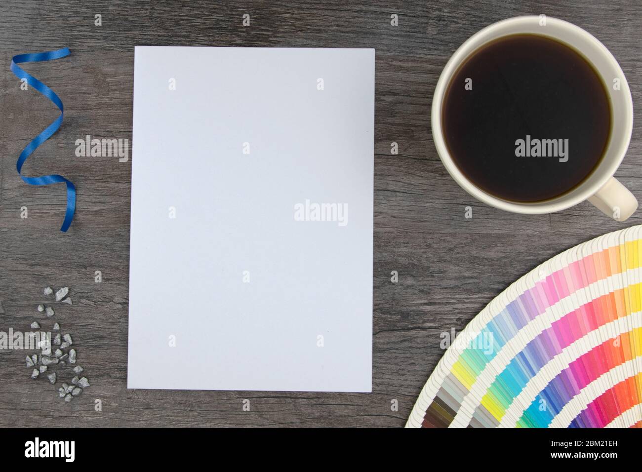 Vue de dessus de la page blanche vide et des cartes de la gamme de couleurs avec une tasse de café sur un plateau en bois Banque D'Images