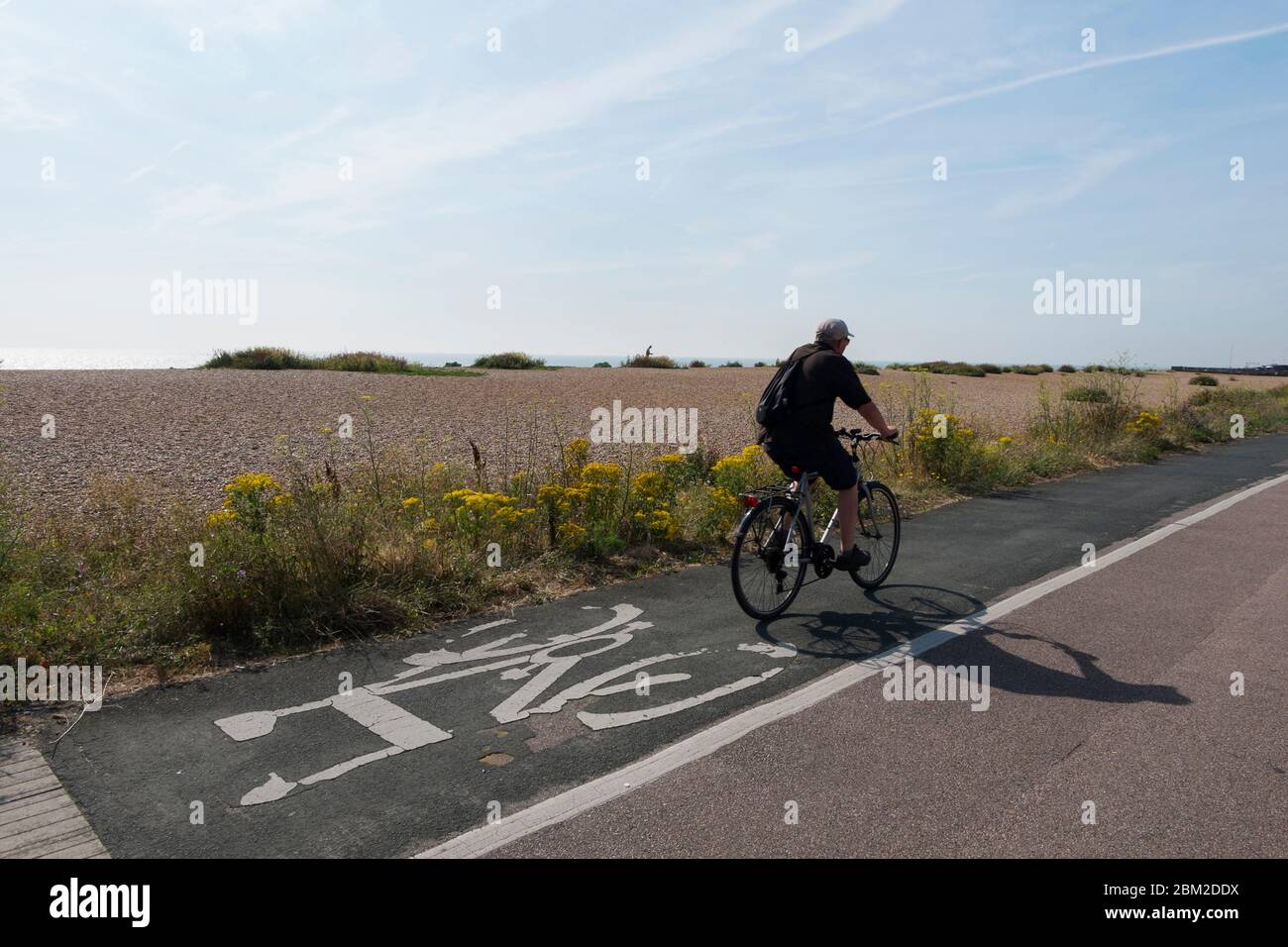 Un homme d'âge moyen qui parcourt le sentier cyclable qui longe le front de Deal à Walmer et Kingsdown, Kent, Royaume-Uni Banque D'Images