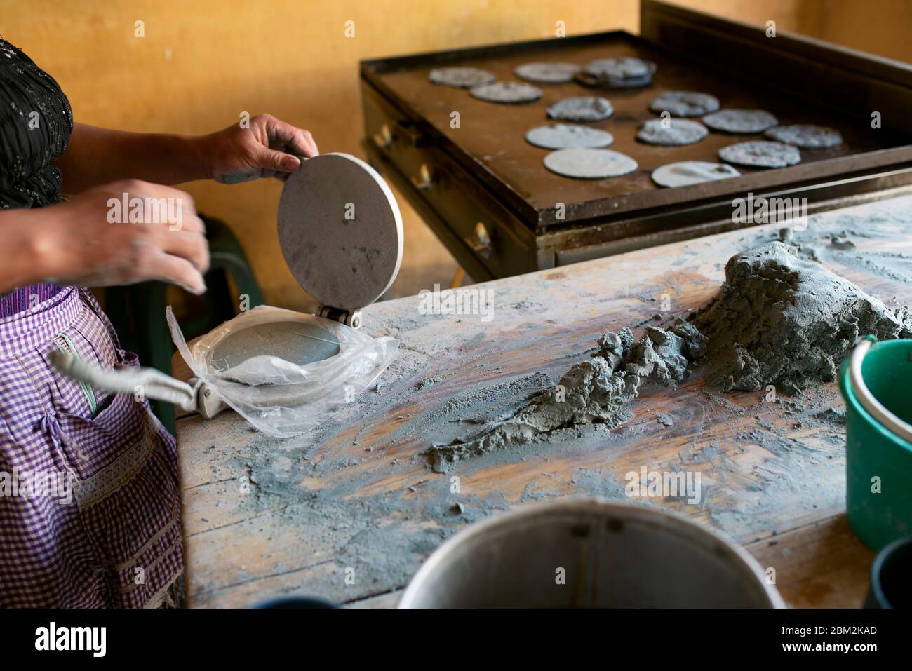 Femme faisant des tortillas de maïs bleu avec presse tortilla. Quetzaltenango (Xela), Guatemala. Mars 2019 Banque D'Images