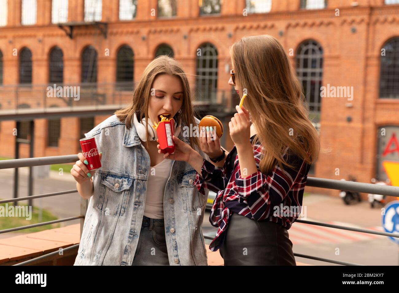 LODZ, POLOGNE - 17 AOÛT 2019 : deux jeunes filles mangent de la nourriture dans une chaîne de restaurants McDonald's et boivent du Coca-Cola. Banque D'Images