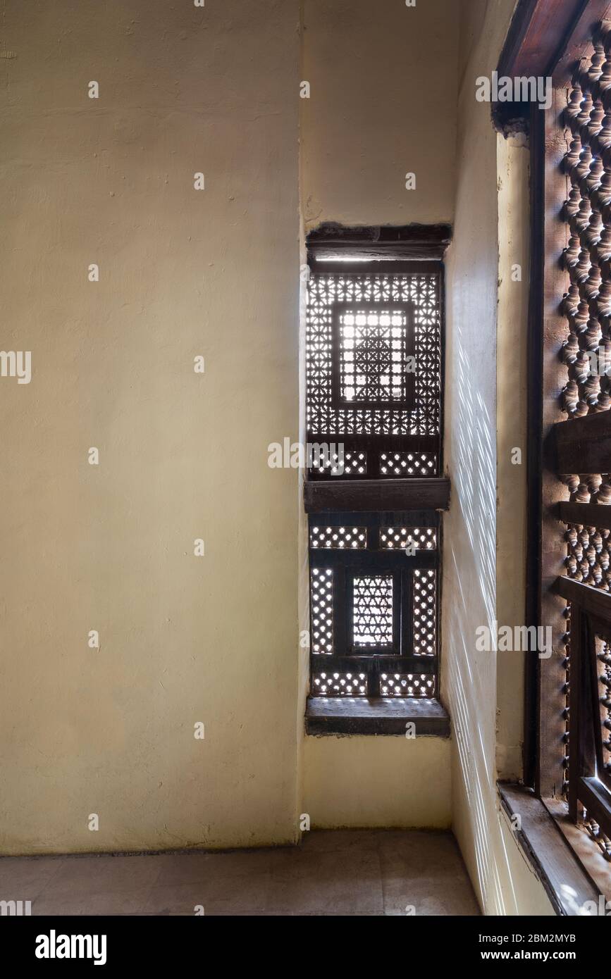 Coin de deux fenêtres en bois entrelacées - Mashrabiya - en mur de pierre dans un bâtiment abandonné Banque D'Images